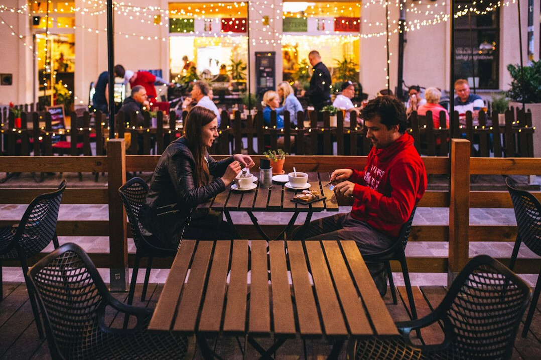 Two people having a conversation at a cafe table