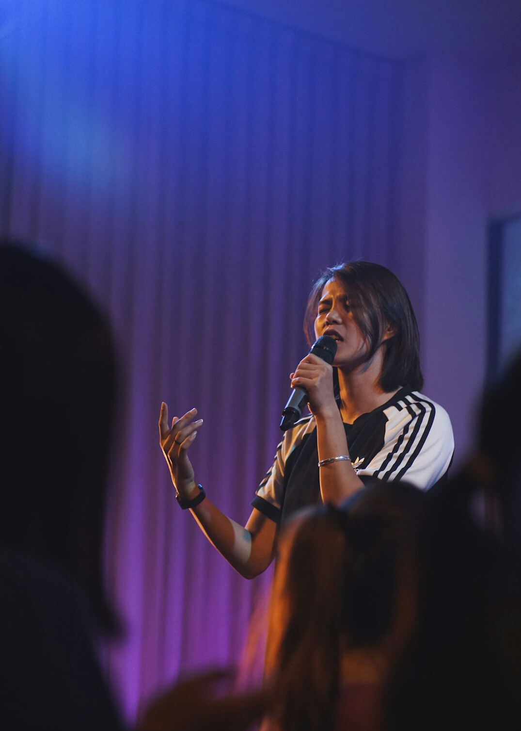 Person speaking into a microphone during a storytelling event